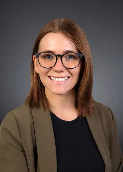 Portrait d’affaires d’une professionnelle avec lunettes sur fond gris