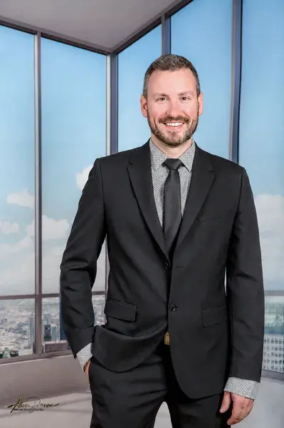 Portrait corporatif d’un homme en complet dans un bureau moderne