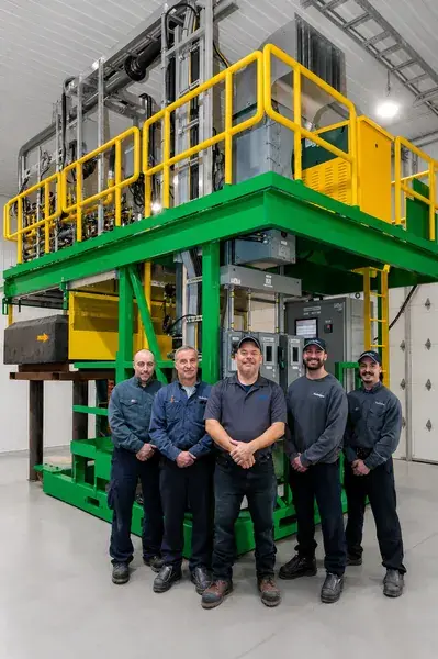 Portrait d’équipe industrielle devant une machine de production en Mauricie